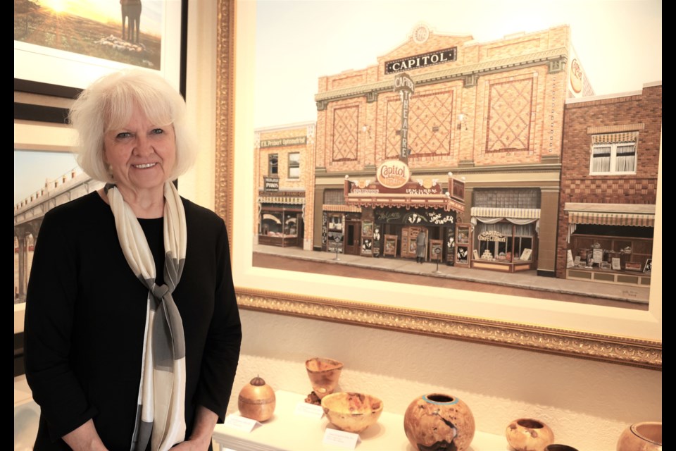 Yvette Moore beside her painting of the old Capitol Theatre during the 2022 Moostletoe tour
